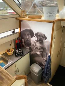 a painting of a man with a dog in a kitchen at Magnifique bateau maison in Ouistreham