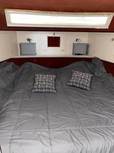 a large bed with two pillows on top of it at Magnifique bateau maison in Ouistreham