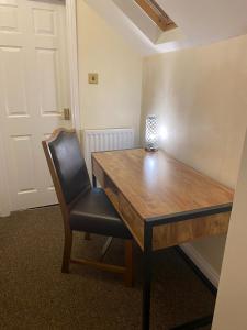 a wooden table and a chair in a room at The Redwell Inn in Barnard Castle