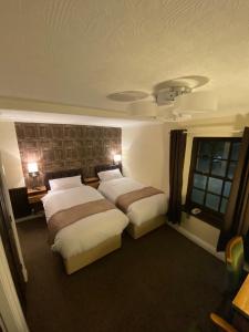 a hotel room with two beds and a window at The Redwell Inn in Barnard Castle