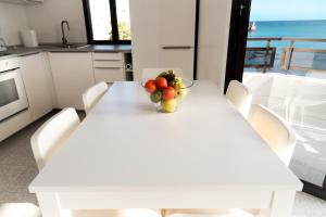 a white table with a bowl of fruit on it at Arinaga Colors, tu casa en la playa in Arinaga