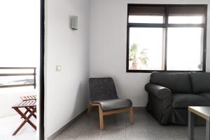 a living room with a couch and a chair at Arinaga Colors, tu casa en la playa in Arinaga