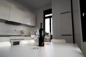 a bottle of wine sitting on a table with two glasses at Arinaga Colors, tu casa en la playa in Arinaga