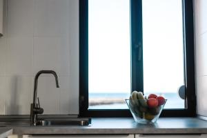 a bowl of fruit on a kitchen counter with a window at Arinaga Colors, tu casa en la playa in Arinaga