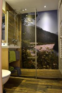 a bathroom with a shower with a painting on the wall at Birg 1414 in Warth am Arlberg