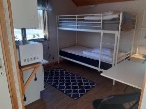 um pequeno quarto com beliches e uma secretária em Holmens Boende och Event em Luleå