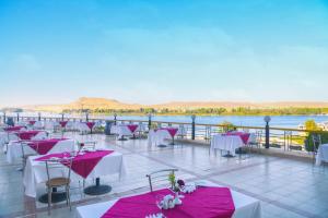 Tolip Aswan Hotel في أسوان: مطعم بطاولات عليها مفارش مائدة حمراء وبيضاء
