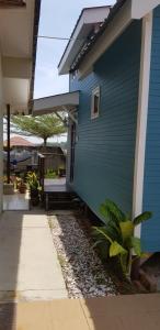 a blue house with a door and a porch at Tiny House B&B in Kampong Baharu Sungai Udang