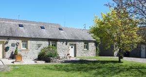 a stone house with a bench in front of it at Unicorn Cottage in Bakewell
