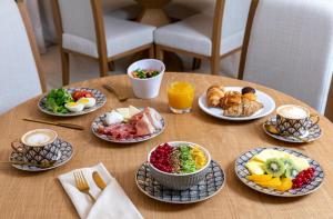 a wooden table with plates of food on it at Room Mate Filippo in Rome