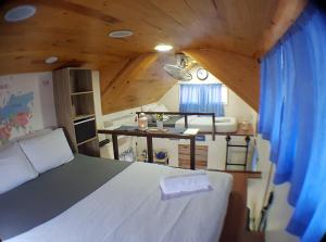 a bedroom with a white bed and a wooden ceiling at Tiny House B&B in Kampong Baharu Sungai Udang
