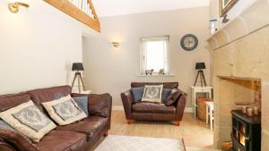 a living room with a couch and a chair at Unicorn Cottage in Bakewell