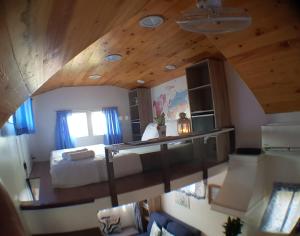 - une chambre avec un lit et un plafond en bois dans l'établissement Tiny House B&B, à Kampong Baharu Sungai Udang