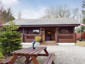 a picnic table in front of a cabin at Secluded 3Bed Lodge with hot tub North Yorkshire in Skipton