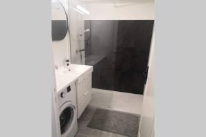 a bathroom with a sink and a washing machine at Vue mer port de garavan in Menton