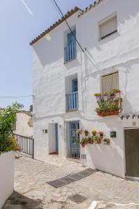 a white house with two windows and flower boxes at La Casita del Arrabal in Casares