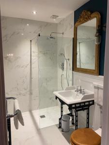 a bathroom with a sink and a shower with a mirror at The Leagate Inn in Coningsby