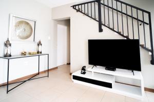 a living room with a flat screen tv on a white wall at Lalata House in Northwold