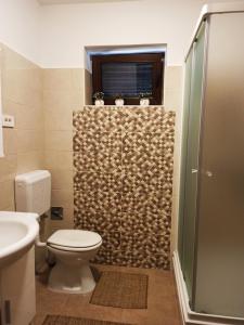 La salle de bains est pourvue d'une douche, de toilettes et d'une fenêtre. dans l'établissement apartman NOA, à Fužine