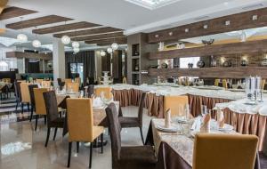 uma sala de jantar com mesas e cadeiras num restaurante em Hotel Avrora em Vityazevo