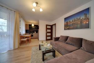 salon z kanapą i stołem w obiekcie Apartamenty Sun & Ski Willa Leśny Dom w mieście Karpacz