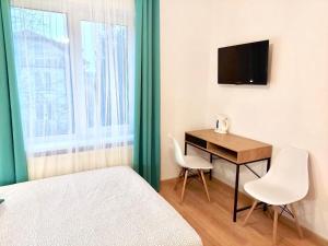 a room with a bed and a desk and a television at B&B Fajne Miejsce in Łeba