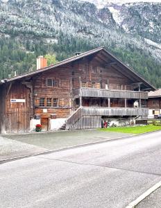 ein großes Holzgebäude an der Seite einer Straße in der Unterkunft Müllerhus in Kandersteg