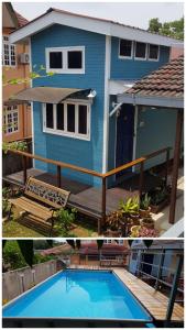 a blue house with a swimming pool in front of it at Tiny House B&B in Kampong Baharu Sungai Udang