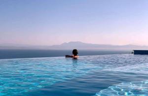 a person sitting in the water in a swimming pool at Duplex Seaview Condo in Durrës