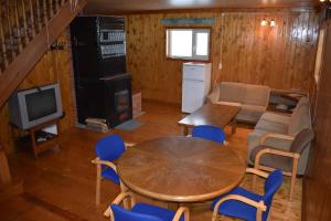 Jõeniidu Holiday House في Trolla: غرفة معيشة مع طاولة وكراسي زرقاء