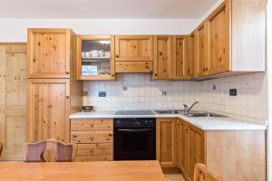a kitchen with wooden cabinets and a black dishwasher at Maso Pejo in Peio