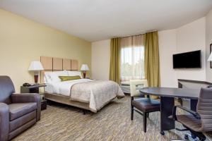 a hotel room with a bed and a desk and chair at Candlewood Suites Cut Off - Galliano by IHG in Galliano +21 photos