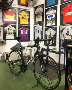 a bike is parked in a room with jerseys at Vila Alaró TI in Alaró