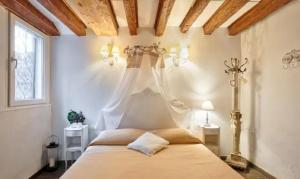 une chambre avec un grand lit à baldaquin dans l'établissement Venice Cadeau, à Venise