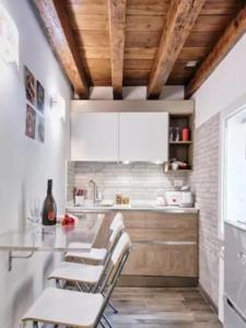 uma cozinha com balcões brancos e tectos em madeira em Venice Cadeau em Veneza