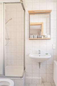 ein Bad mit einem Waschbecken und einer Dusche in der Unterkunft Hotel Dortmunder Hof in Würzburg
