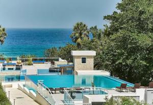 a house with a swimming pool next to the ocean at Playa Laguna Vacation Condos in Sosúa