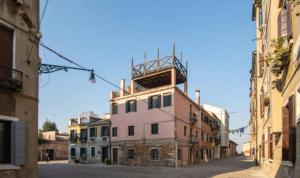 un bâtiment avec une tour au sommet d'une rue dans l'établissement Venice Cadeau, à Venise