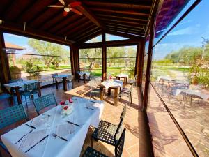 uma sala de jantar com mesas e cadeiras num pátio em Agriturismo l'Ovile em San Michele