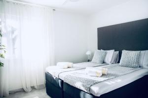a bedroom with a large bed with white and blue pillows at The Grande - Huge terrace - Amazing sea views - Tastefully Furnished - Access to rooftop terrace and gym - Hillside Apartments Rogoznica in Rogoznica