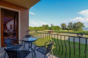 a balcony with a table and chairs and a view of the water at APARTAMENT JAN-54 Krynica Morska in Krynica Morska