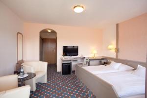una camera d'albergo con due letti e una televisione di Schreyers Hotel Restaurant Mutzel a Schluchsee