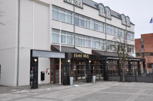 a large white building with a sign that reads flood rise at Hotel Medi in Ikast