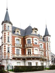 ein großes Backsteingebäude mit zwei Türmchen in der Unterkunft Appartement "POULAIN" en Centre-ville linge inclus in Blois