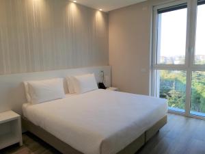 sypialnia z białym łóżkiem i dużym oknem w obiekcie Novo Hotel Rossi w Weronie +37 zdjęć