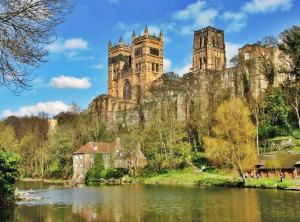 a castle with two towers on a hill next to a river at Luke stays - Cheveley Park in Durham