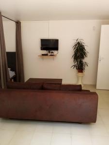 sala de estar con sofá y TV de pantalla plana en Chez Sylvie et Amador, en Las Illas
