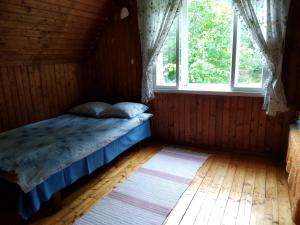 a bedroom with a bed in a room with a window at Jõeniidu Holiday House in Trolla