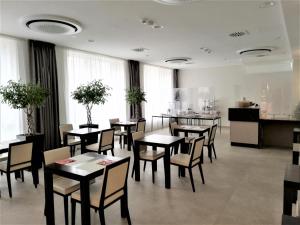 jadalnia ze stołami, krzesłami i oknami w obiekcie Novo Hotel Rossi w Weronie