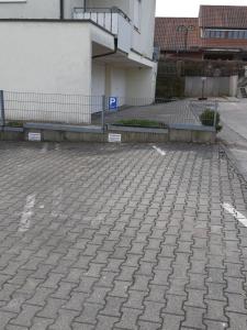 a brick parking lot with a fence and a building at Apartment in Abstatt mit 5min zur A81 in Abstatt